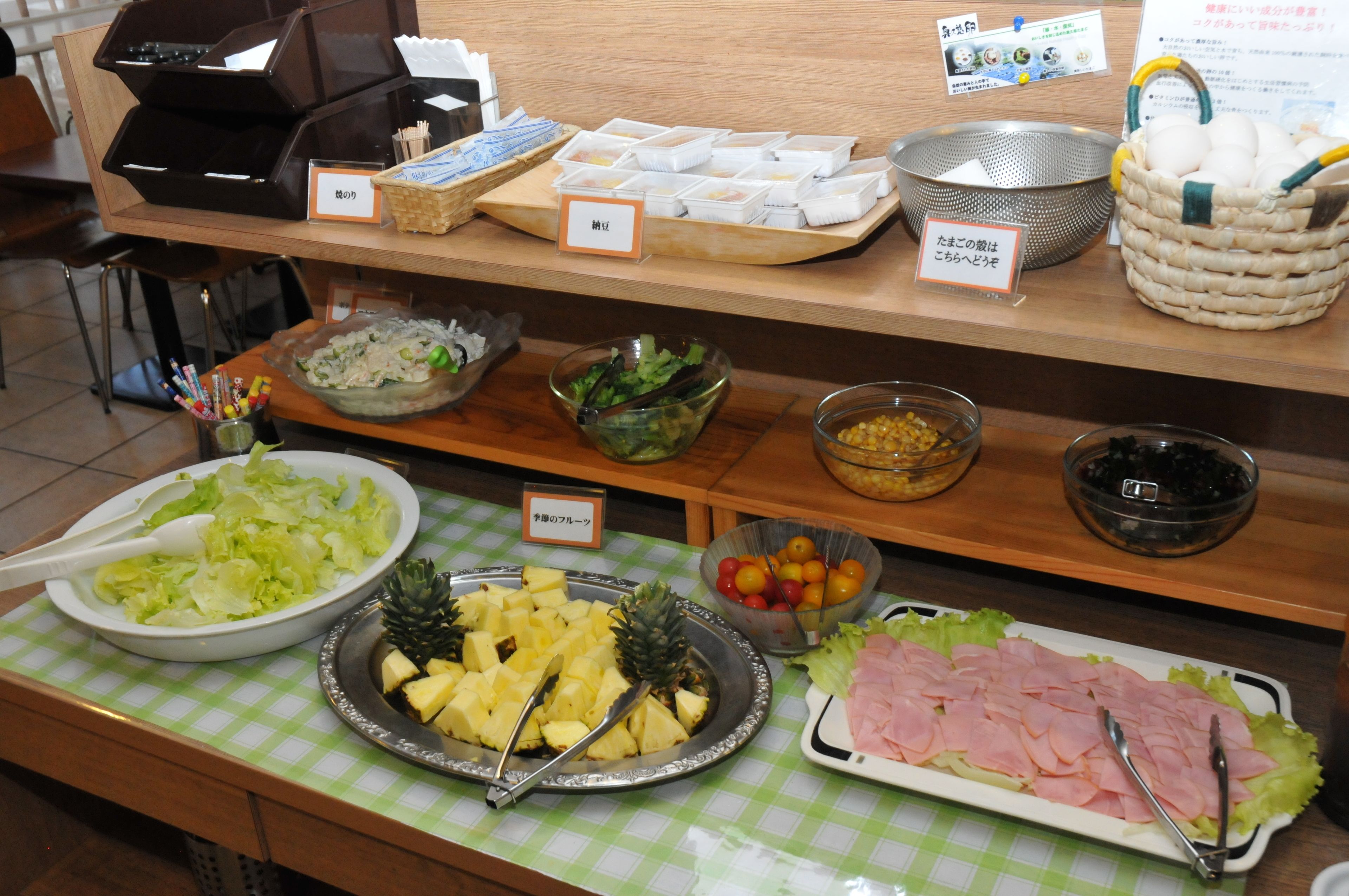 A buffet with various food items including salads, fruits, and meats.