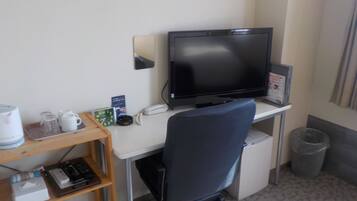 A small office space with a desk, chair, computer, and various office supplies.