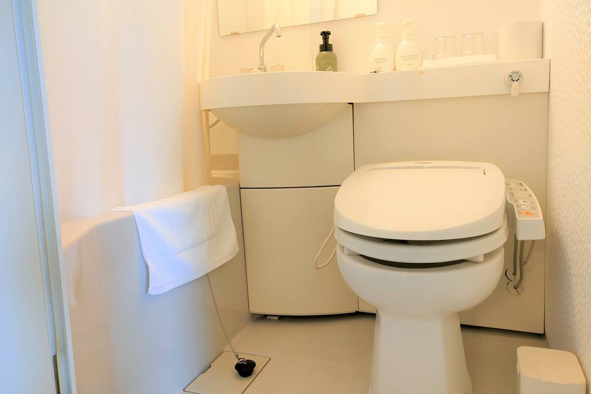 Ein Badezimmer mit Toilette, Waschbecken und Handtuchhalter.