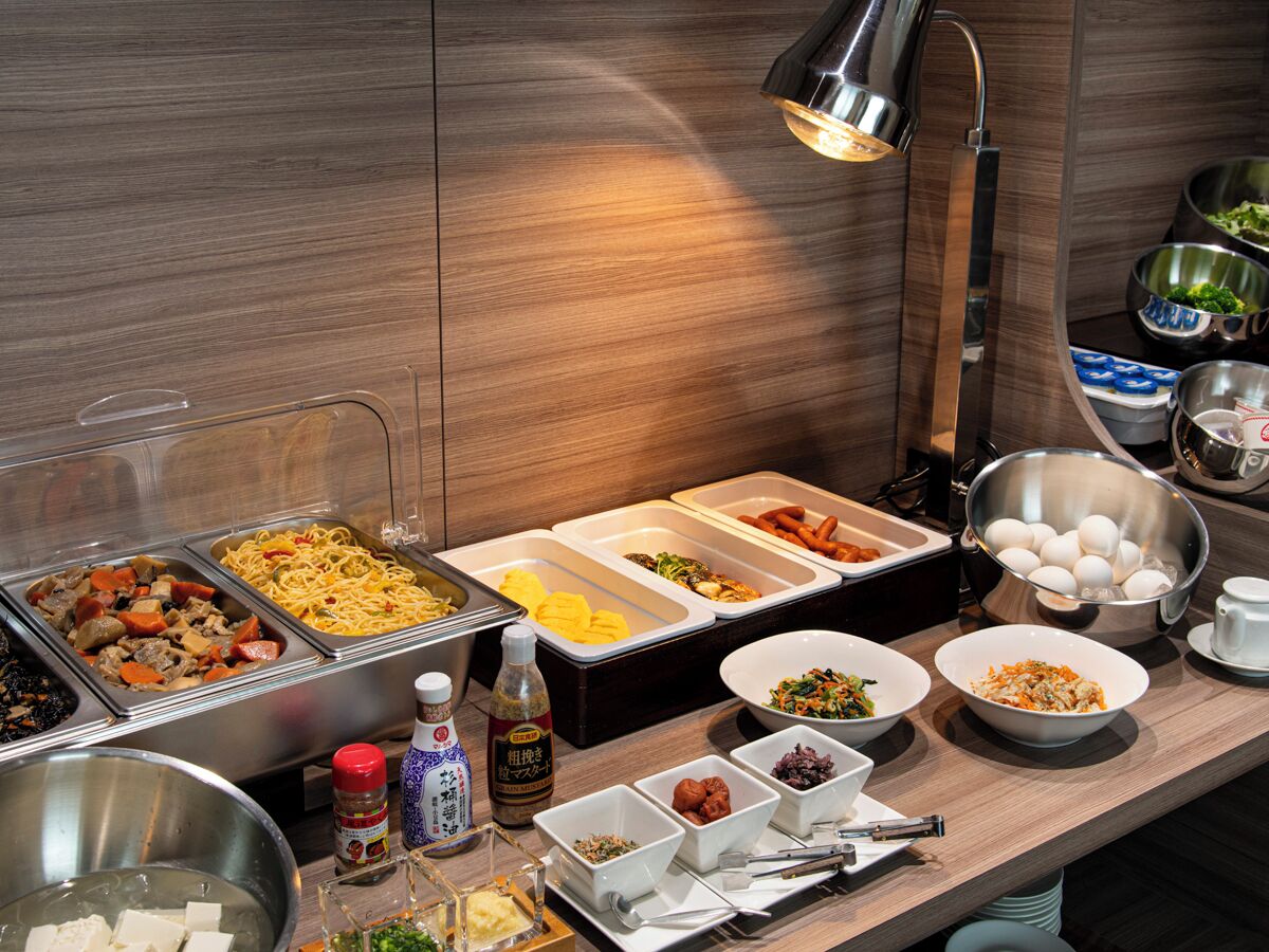 A buffet with various food options, including noodles, meats, and vegetables.