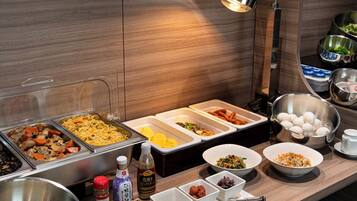 A buffet with various food options, including noodles, meats, and vegetables.