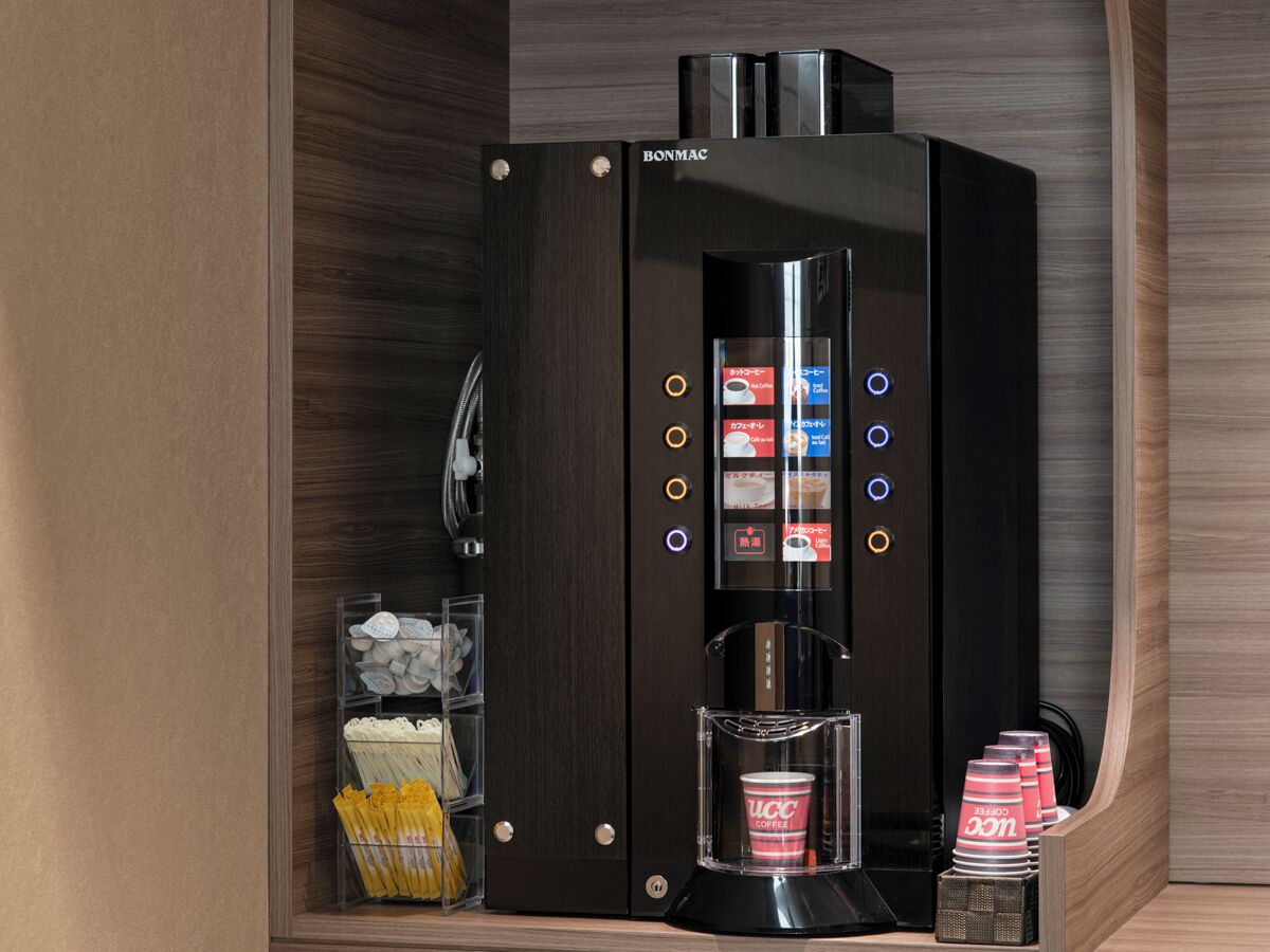 Een compact koffieapparaat met een digitaal display, een koffiemolen en een bekerhouder.