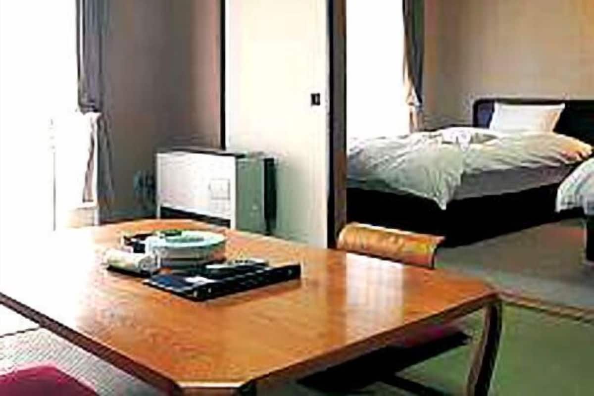 A hotel room with a bed, a desk, and a chair.