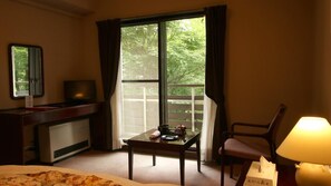 A hotel room with a bed, a desk with a television, a table with a lamp, and a window with curtains. - Zao Onsen Levert Zao (Yamagata)