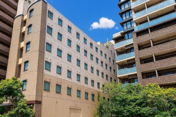 Un hotel de varios pisos con fachada uniforme, múltiples ventanas y balcones.