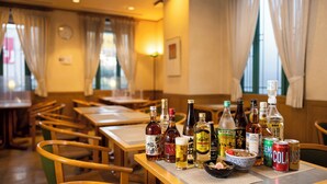 A restaurant interior with tables, chairs, and various bottles and cans on the tables. - Hotel Dorf Shizuoka (Shizuoka)
