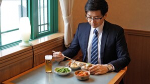A man dining at a table with various dishes, a beer, and a lamp. - Hotel Dorf Shizuoka (Shizuoka)