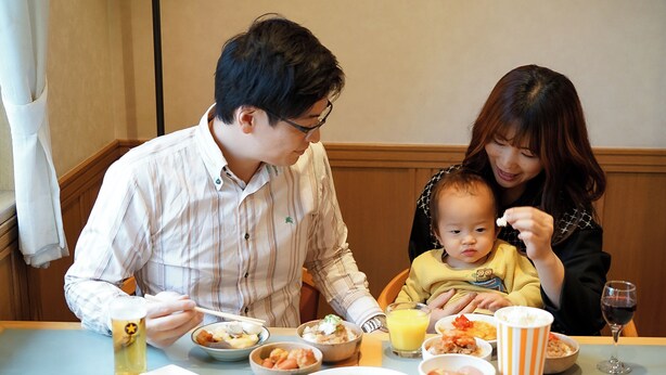A family dining at a restaurant with various dishes and drinks on the table. - Hotel Dorf Shizuoka (Shizuoka)