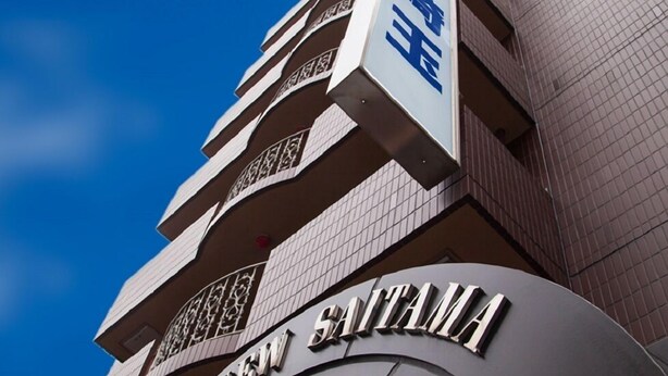 Um edifício de hotel moderno com uma placa de destaque que diz "HOTEL NEW SITA".