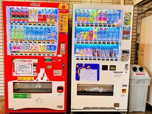 Two vending machines, one red and one white, with various beverages and snacks. - Hotel New Saitama (Saitama)