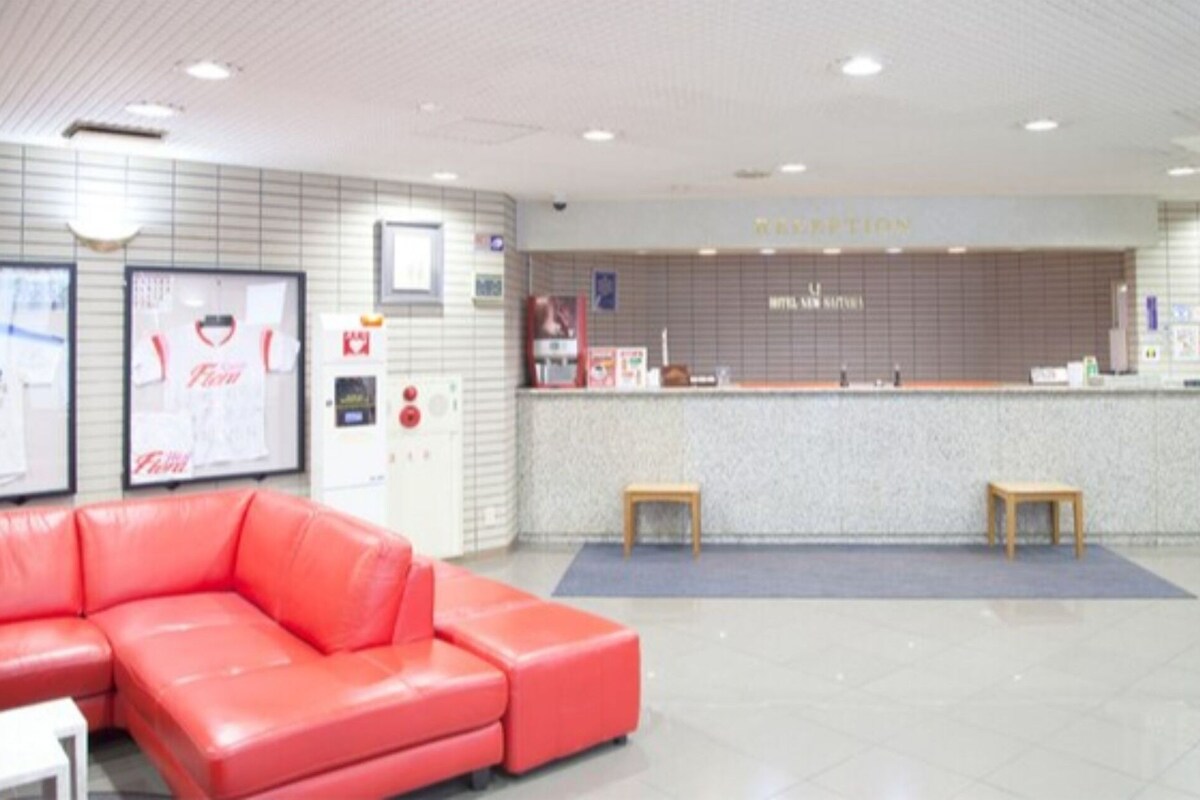 A reception area with a reception desk, a red sofa, and a small wooden table.