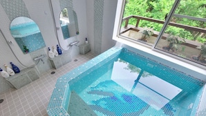 A swimming pool with a tiled edge, a window with a view of greenery, and a bathroom with a mirror and toiletries. - Château Le Fleur (Ito)