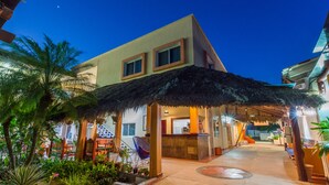 A hotel with a reception area, outdoor seating, and a thatched roof structure. - Hotel Meson de Mita (Punta de Mita)