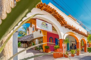 A hotel with a colorful facade, including a sign for 'Hotel Meson de Mita'.