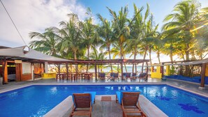 A pool area with lounge chairs, a covered seating area, and palm trees. - Hotel Meson de Mita (Punta de Mita)
