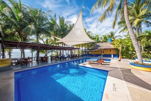 Una piscina al aire libre, sillones reclinables de piscina