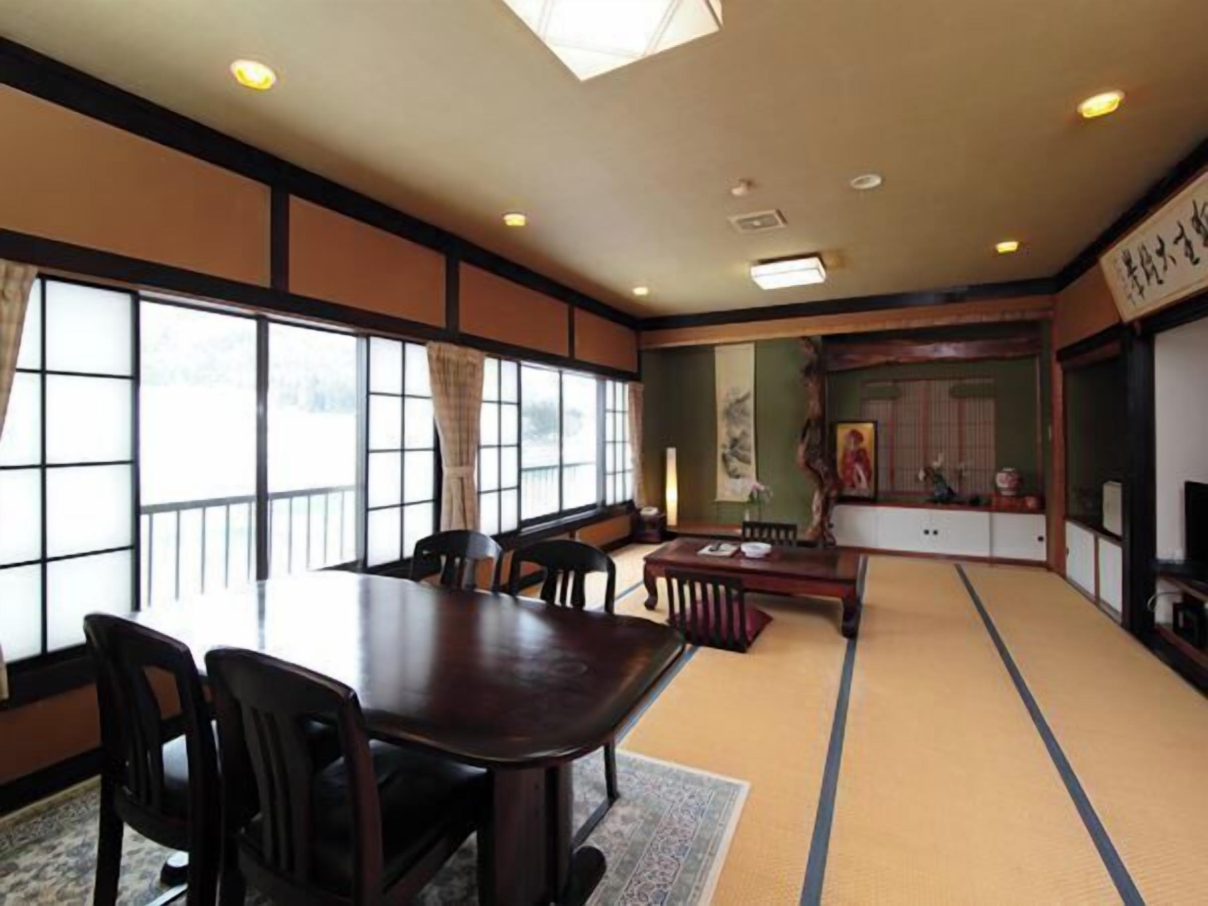 Una habitación japonesa tradicional con suelo de tatami, una mesa baja y sillas.
