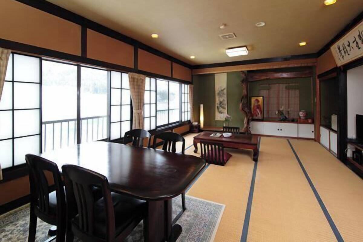 Ein traditioneller japanischer Raum mit Tatami-Boden, einem niedrigen Tisch und Stühlen.
