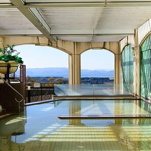 An indoor swimming pool with a view of mountains.