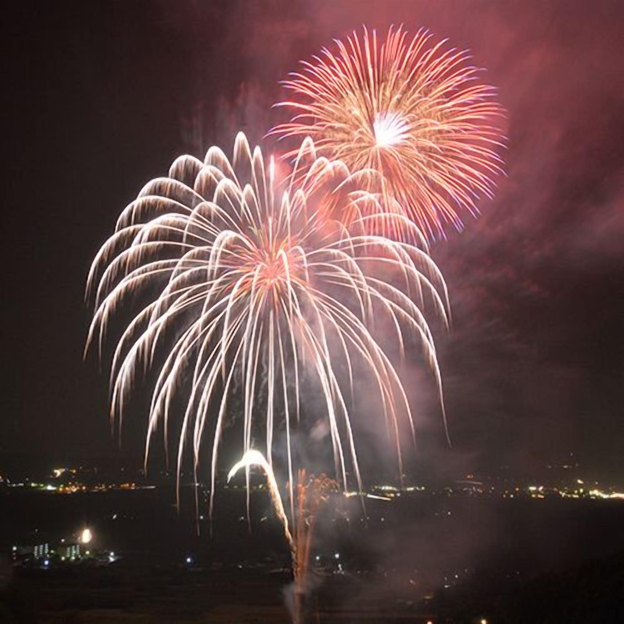 Une scène nocturne illuminée par des feux d’artifice.