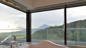 Une salle de bain moderne dotée d’une grande baignoire, d’une douche et offrant une vue sur une montagne et un lac.