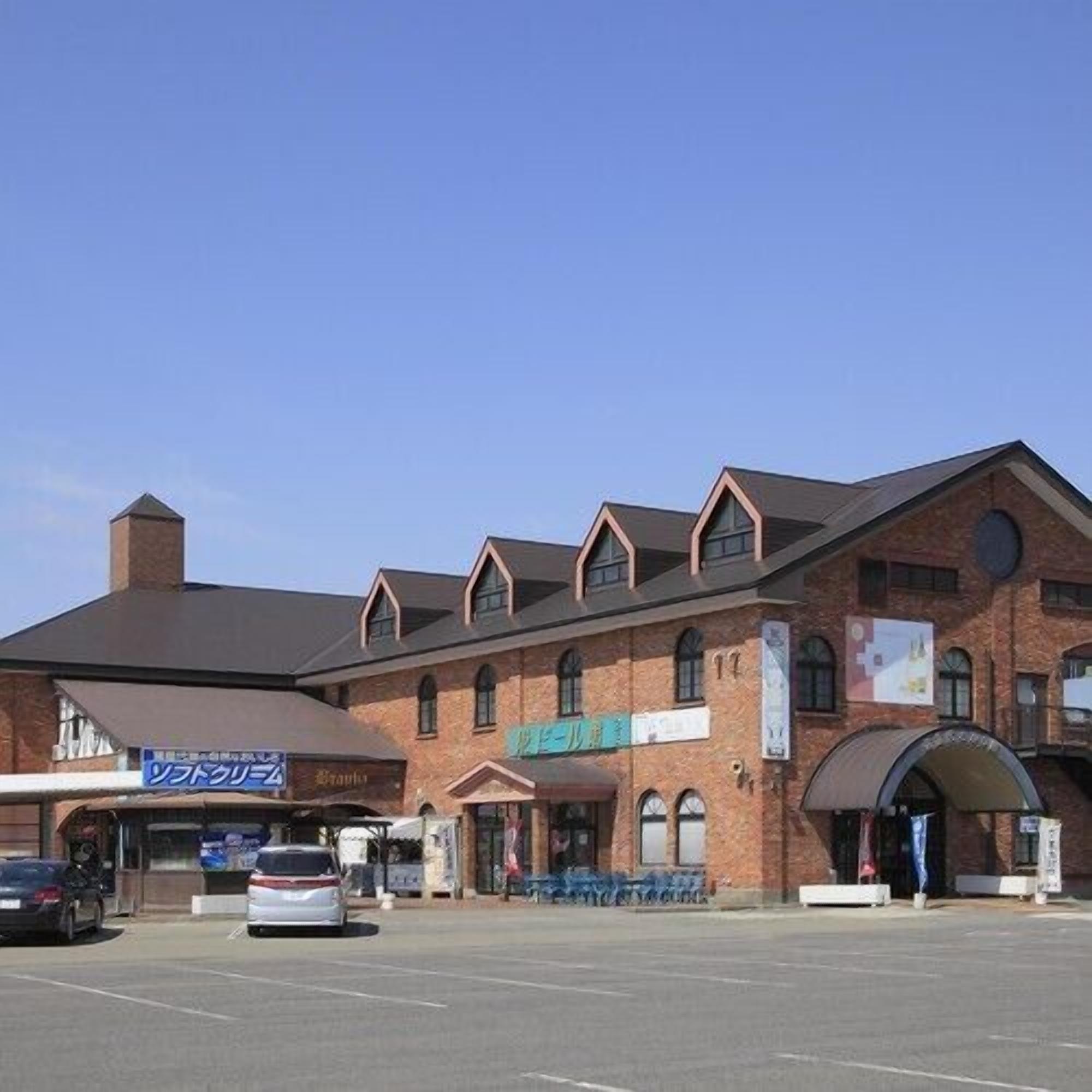 A multi-story brick building with a parking lot in front.