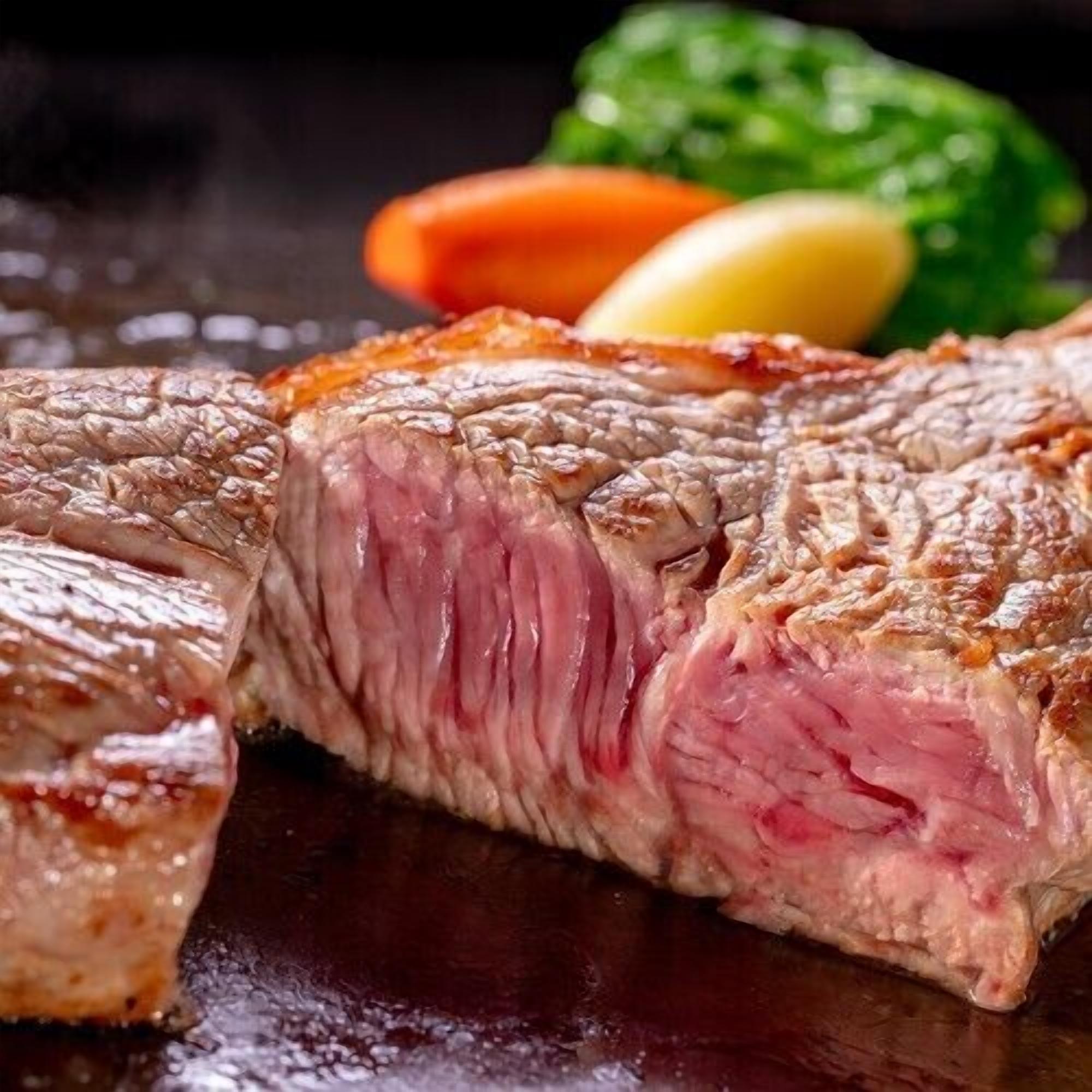A steak with a crust on a dark surface.