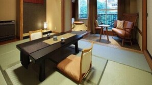Ein traditioneller japanischer Raum mit Tatami-Böden, einem niedrigen Tisch und Blick ins Freie.