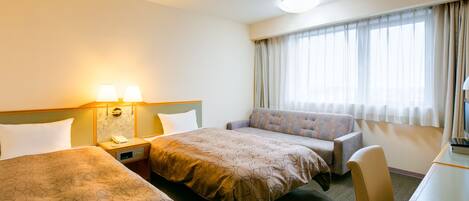 Une chambre d’hôtel avec deux lits, un canapé, un bureau et une fenêtre avec des rideaux.