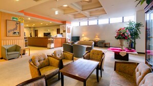 A spacious lobby with multiple seating areas, a reception desk, and a large window providing natural light. - Hotel Sunroute Tochigi (Tochigi)