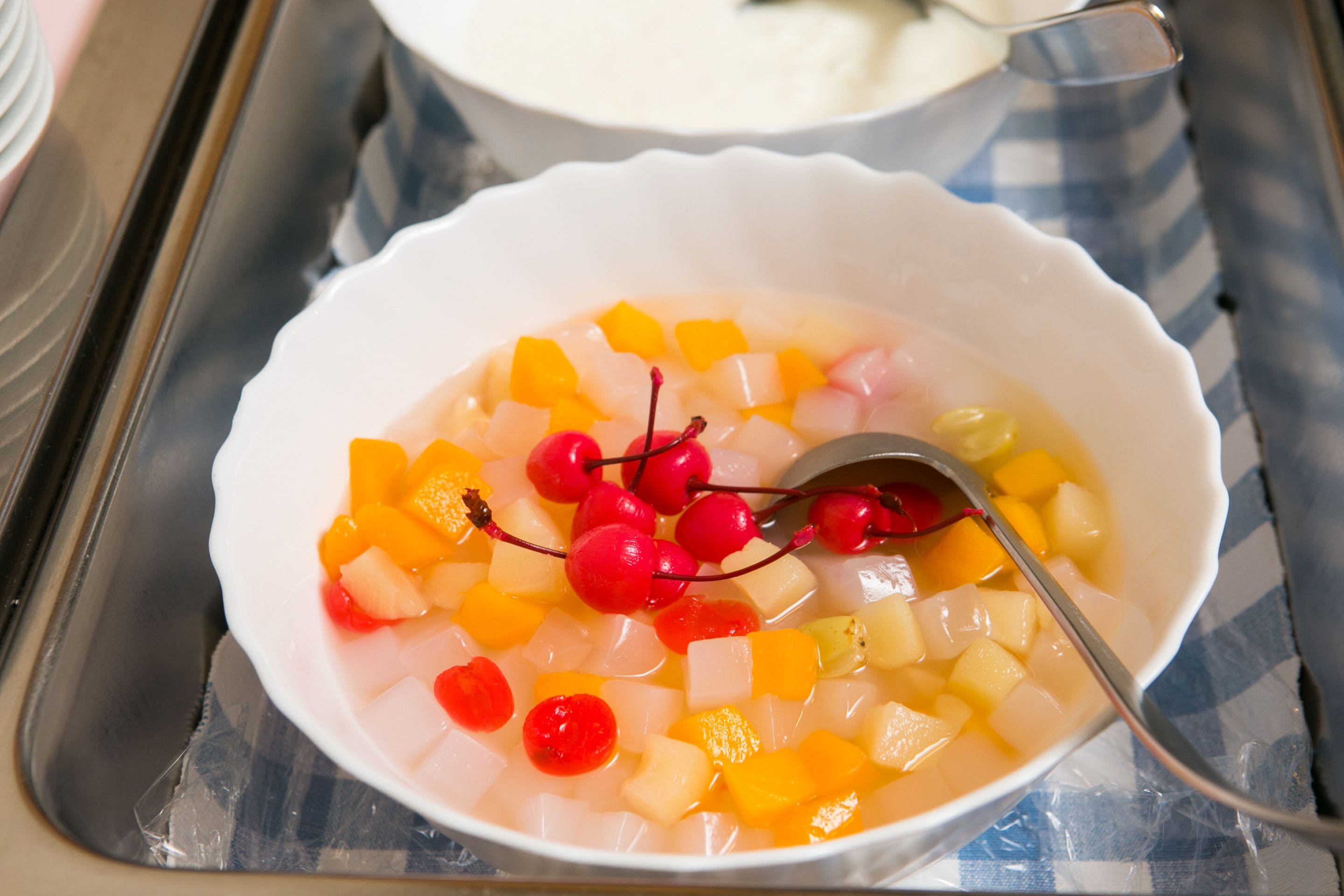Un bol de salade de fruits avec une cuillère.