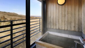 A wooden interior with a large window, a hot tub, and a view of a snowy landscape. - Kishigon Ryokan (Shibukawa)