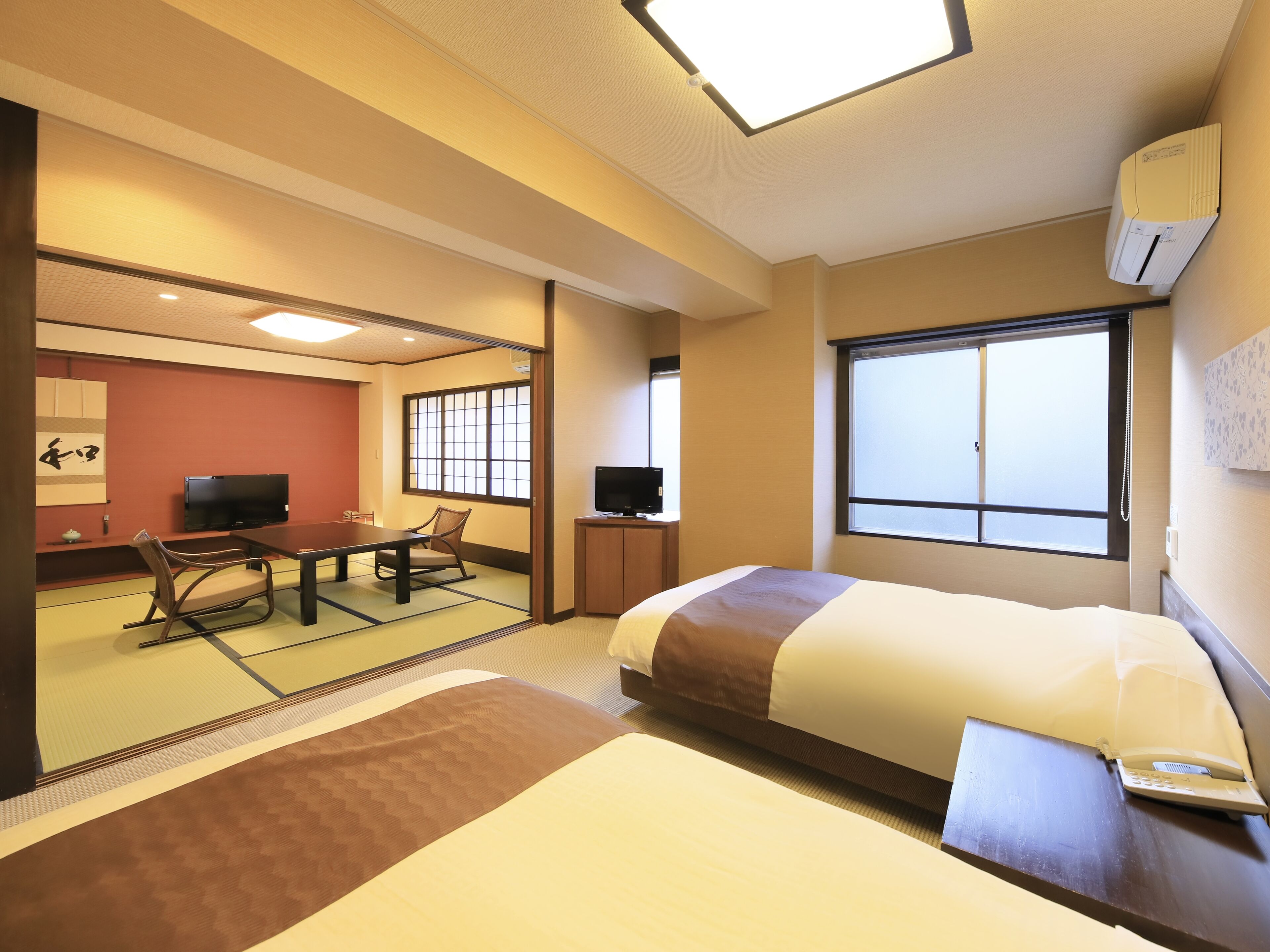 Une chambre d’hôtel avec un lit, un bureau et une chaise, une télévision et une grande fenêtre.