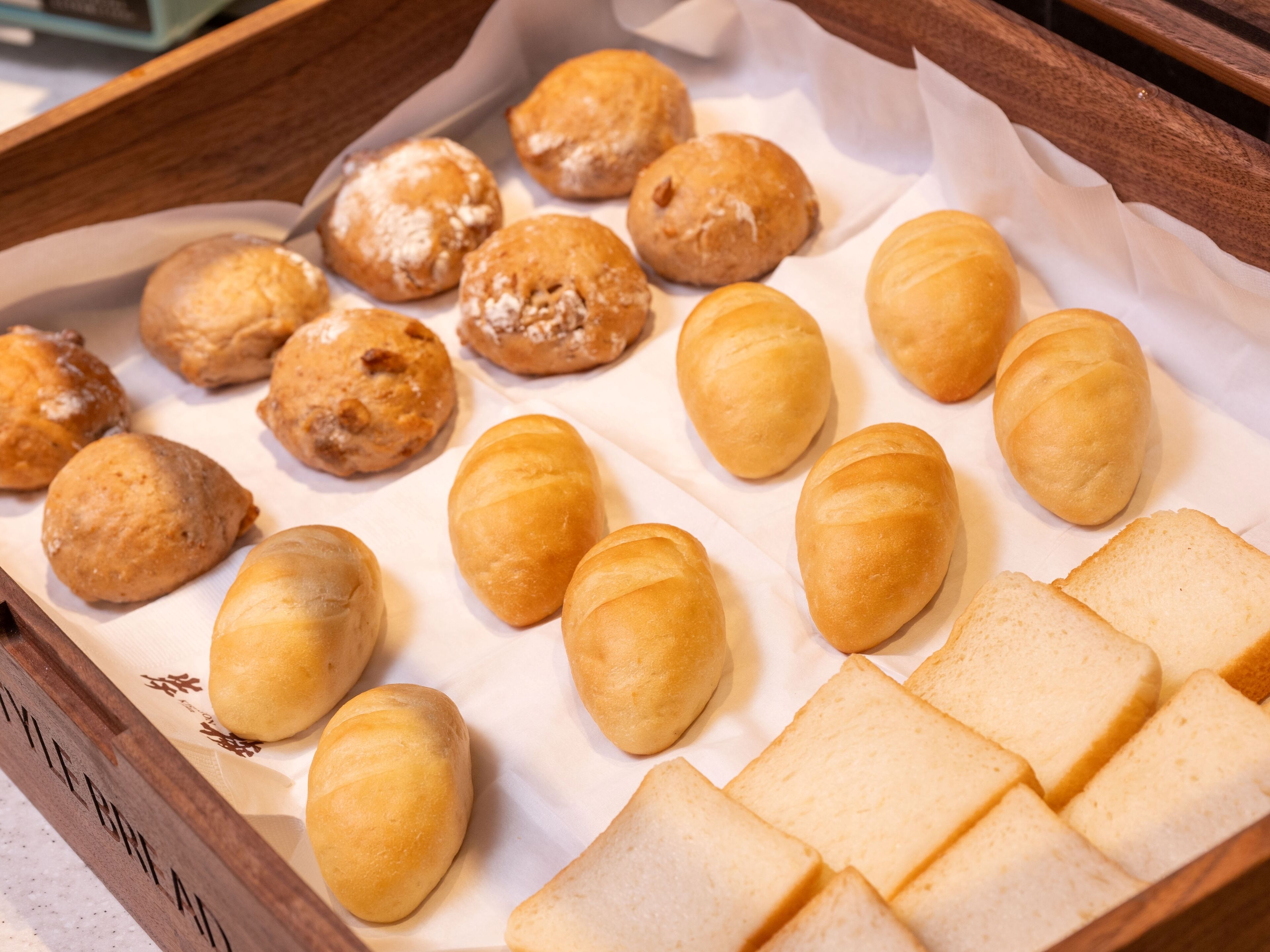A tray of assorted pastries and bread slices.