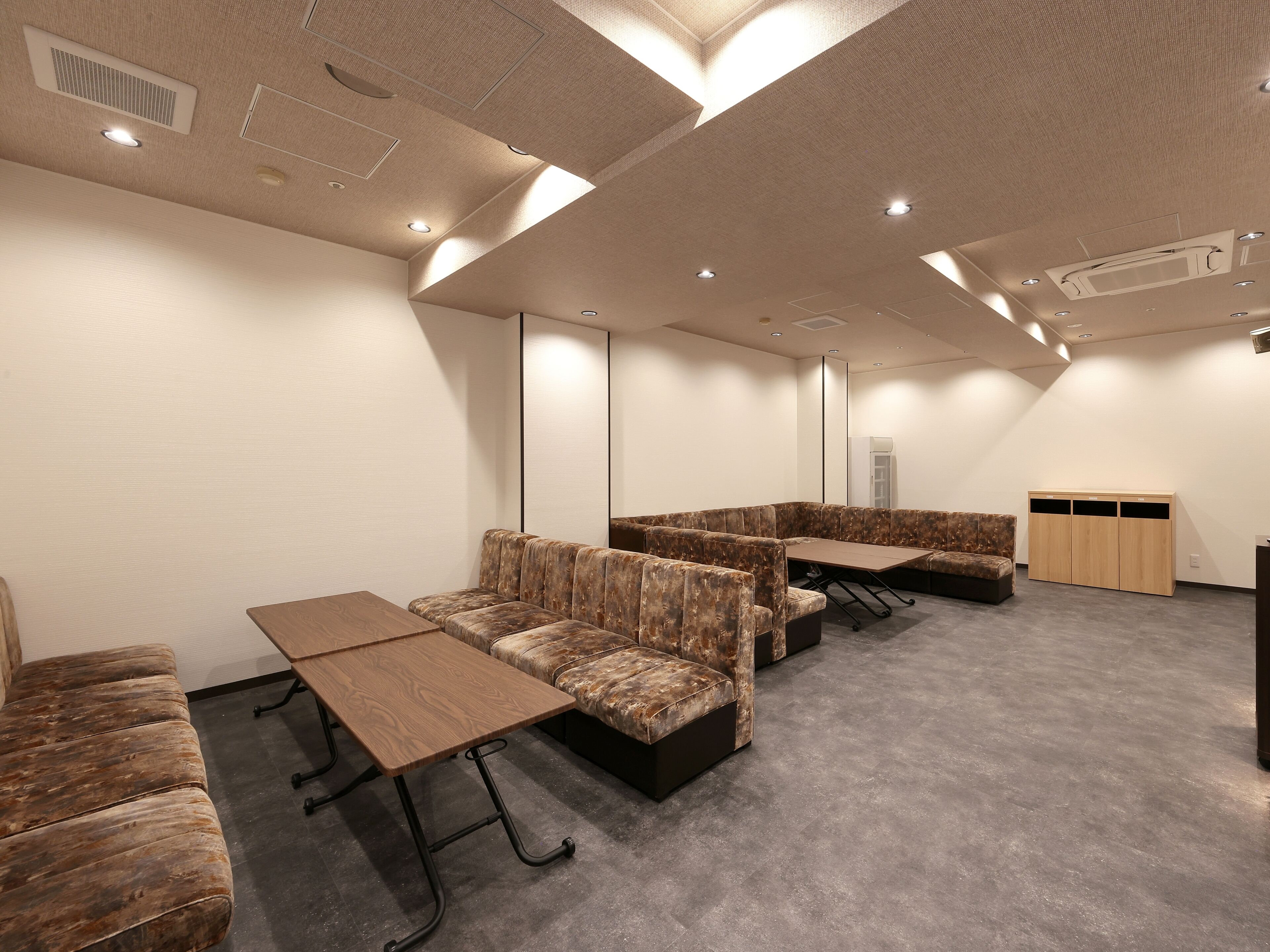 A conference room with a long table, several upholstered seating areas, and a wardrobe.