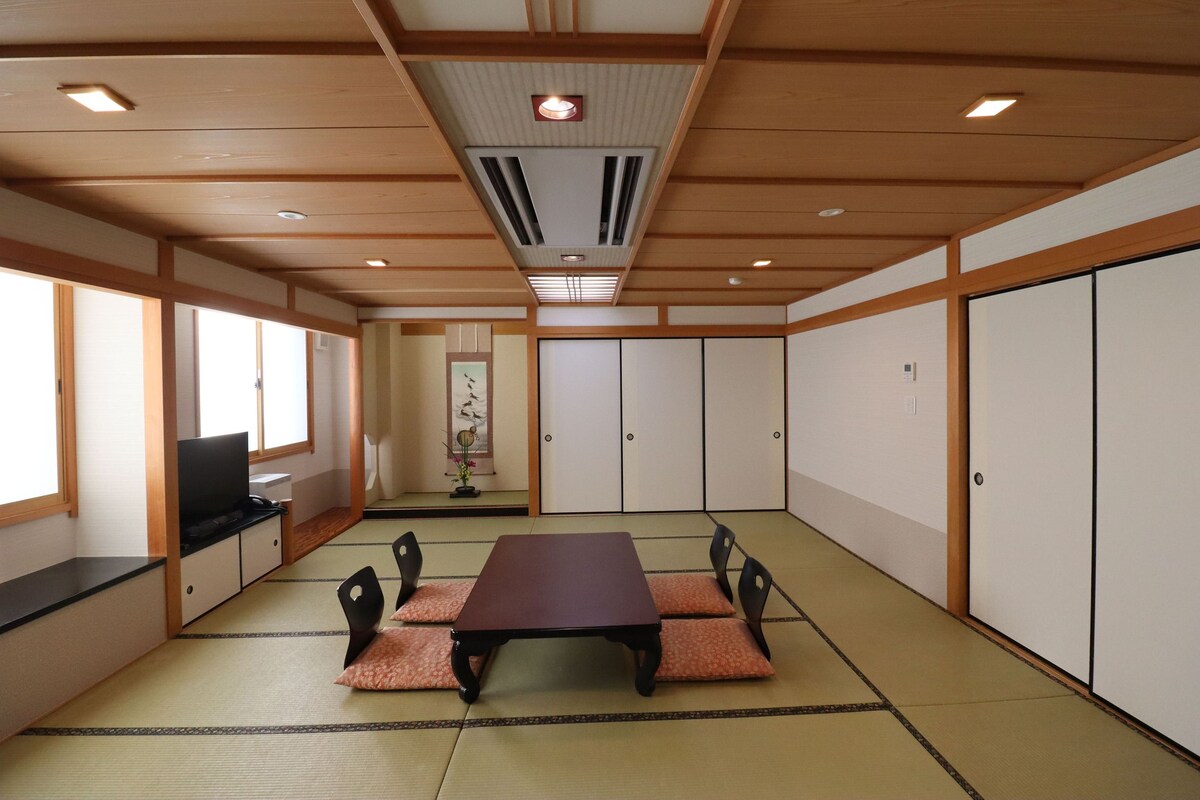 A traditional Japanese room with tatami flooring, a low table, and sliding doors.