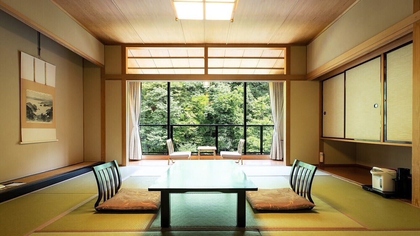 Une pièce de style japonais traditionnel, avec un sol recouvert de tatamis, une table basse et des portes coulissantes.