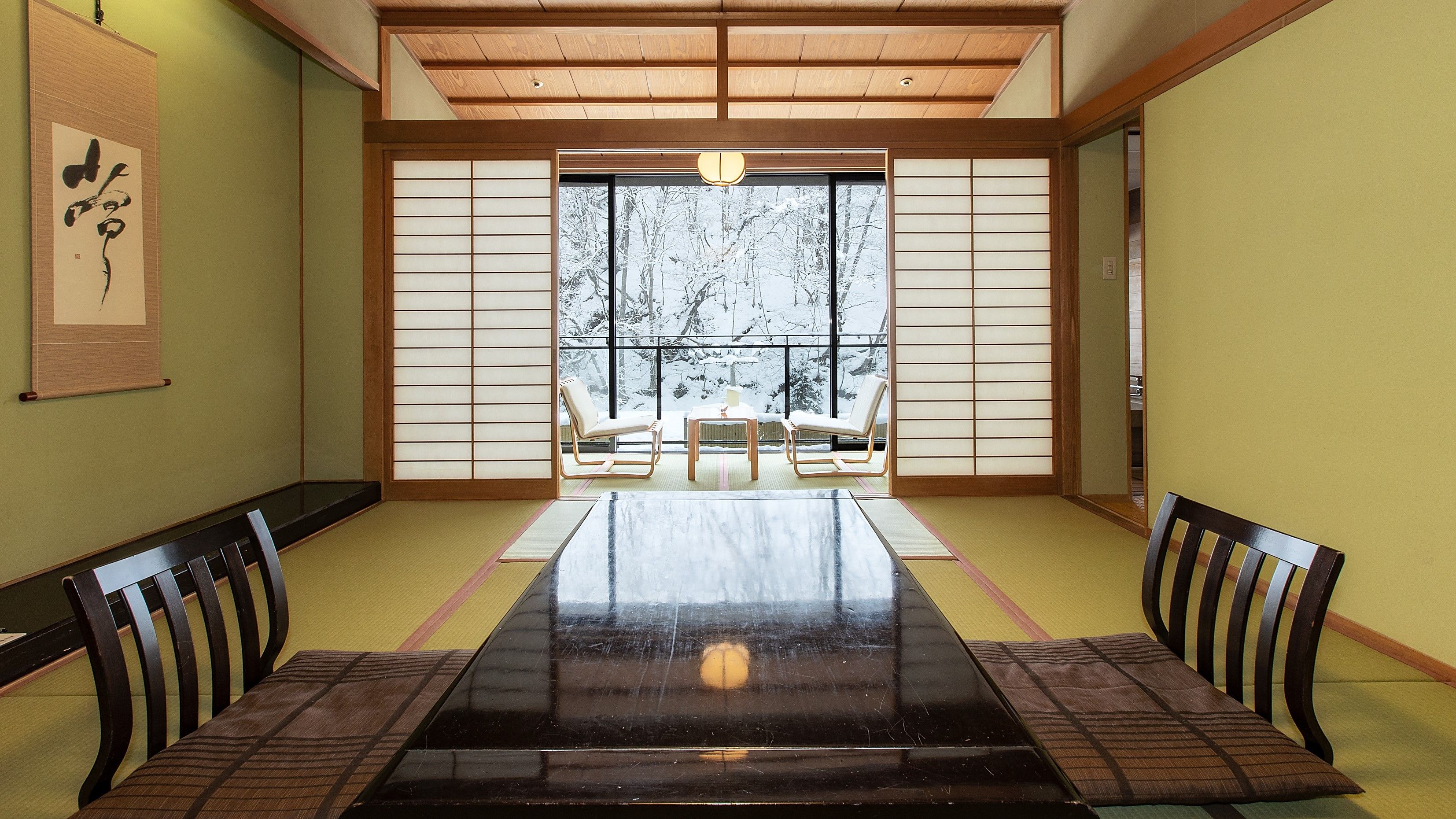 Ein traditioneller japanischer Raum mit Tatami-Böden, einem niedrigen Tisch und Schiebetüren.