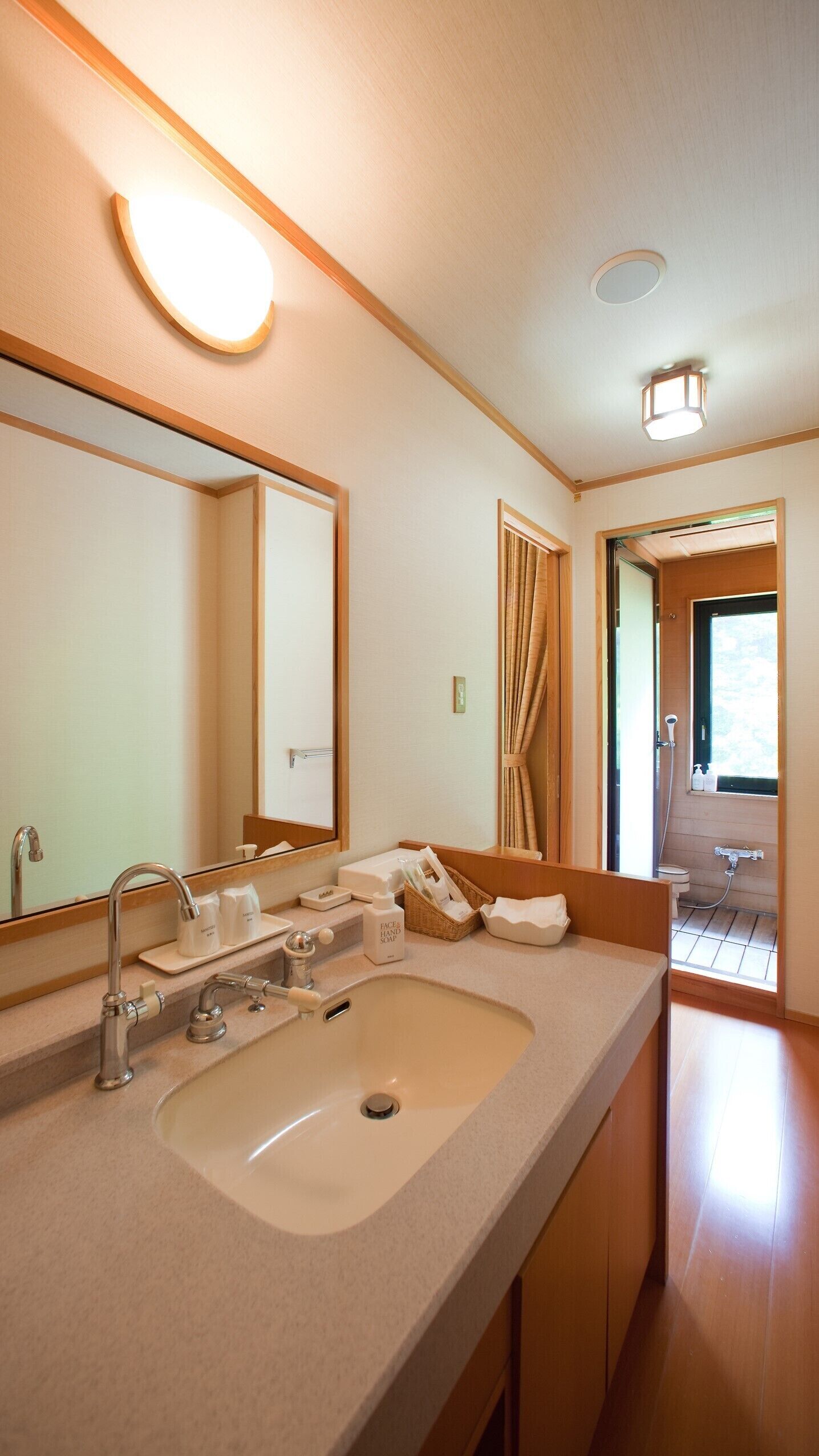 Une salle de bain moderne avec un grand lavabo, un miroir et un espace douche.