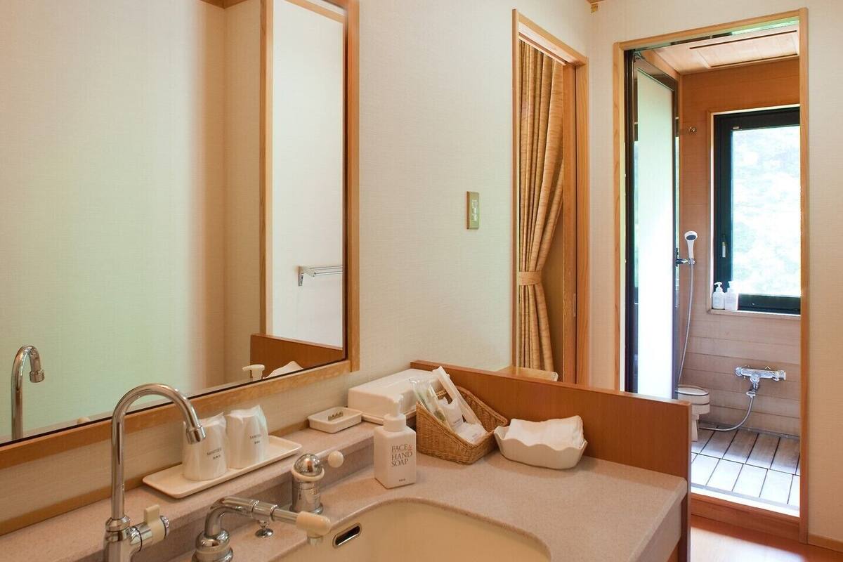 Une salle de bain moderne avec un grand lavabo, un miroir et un espace douche.