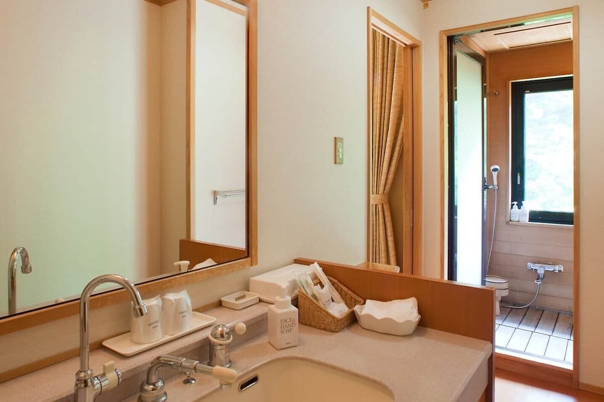 Une salle de bain moderne avec un grand lavabo, un miroir et un espace douche.