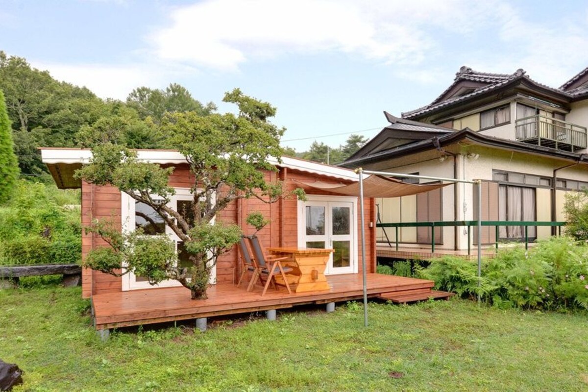 A traditional Japanese house with a wooden deck and a small garden.
