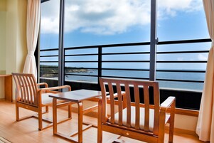 Una habitación con un ventanal grande, muebles de madera y vista al mar.