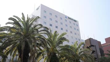 A multi-story hotel with a modern design, featuring a prominent logo on the facade.