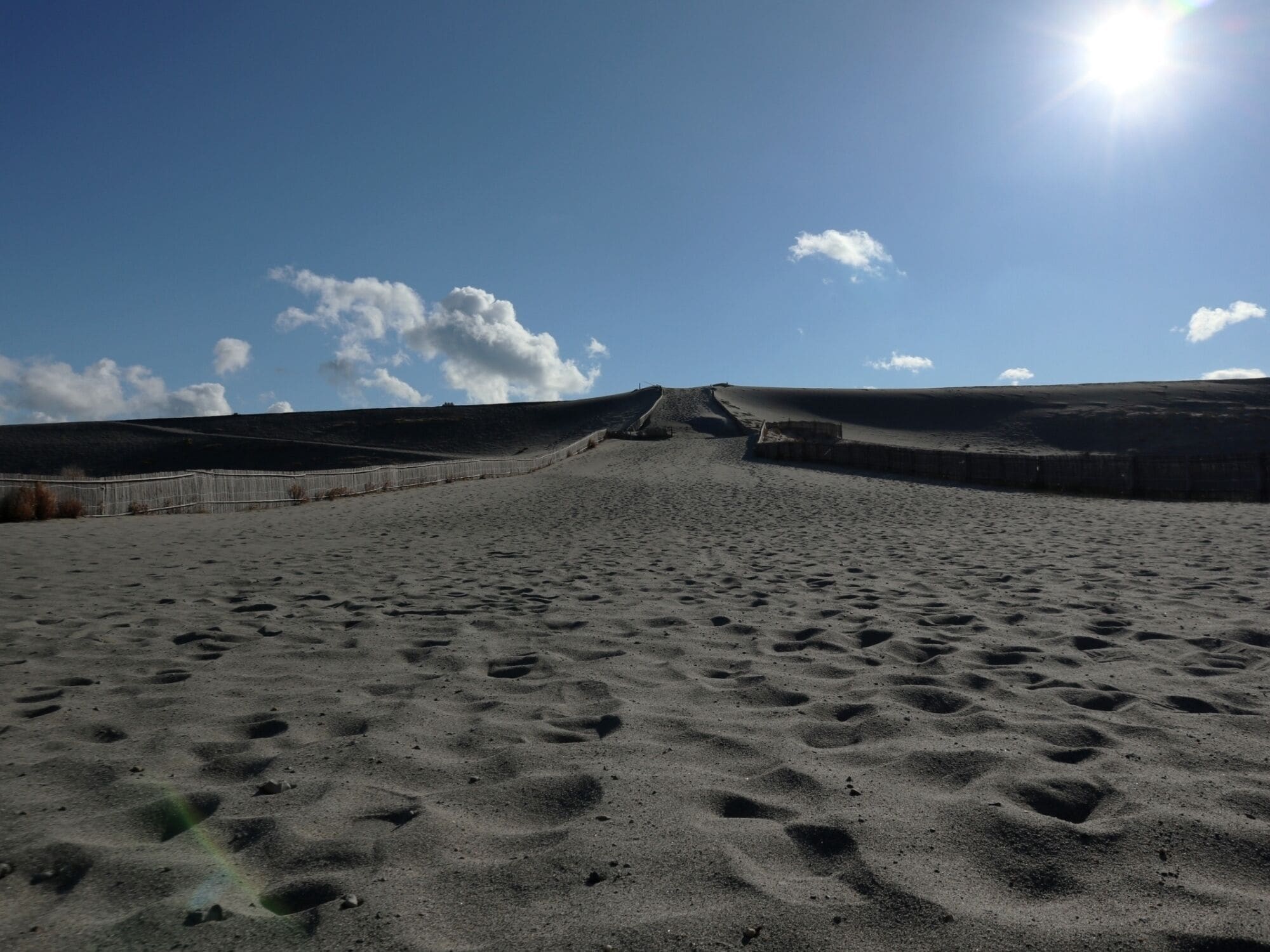 Un paysage désertique, avec un ciel dégagé et un soleil éclatant.