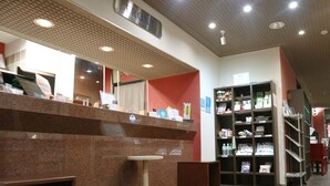 A reception area with a marble counter, a small table, and a red carpet. There are shelves with various items and a sign on the wall. - Hamamatsu Station Hotel (Hamamatsu)