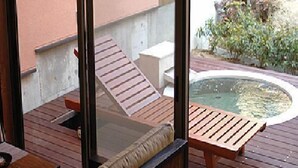 A wooden deck with lounge chairs and a hot tub. - Time Resort Kakureya (Ibaraki)