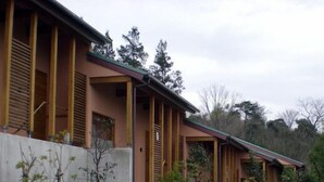A modern building with a flat roof, wooden beams, and a concrete wall. - Time Resort Kakureya (Ibaraki)