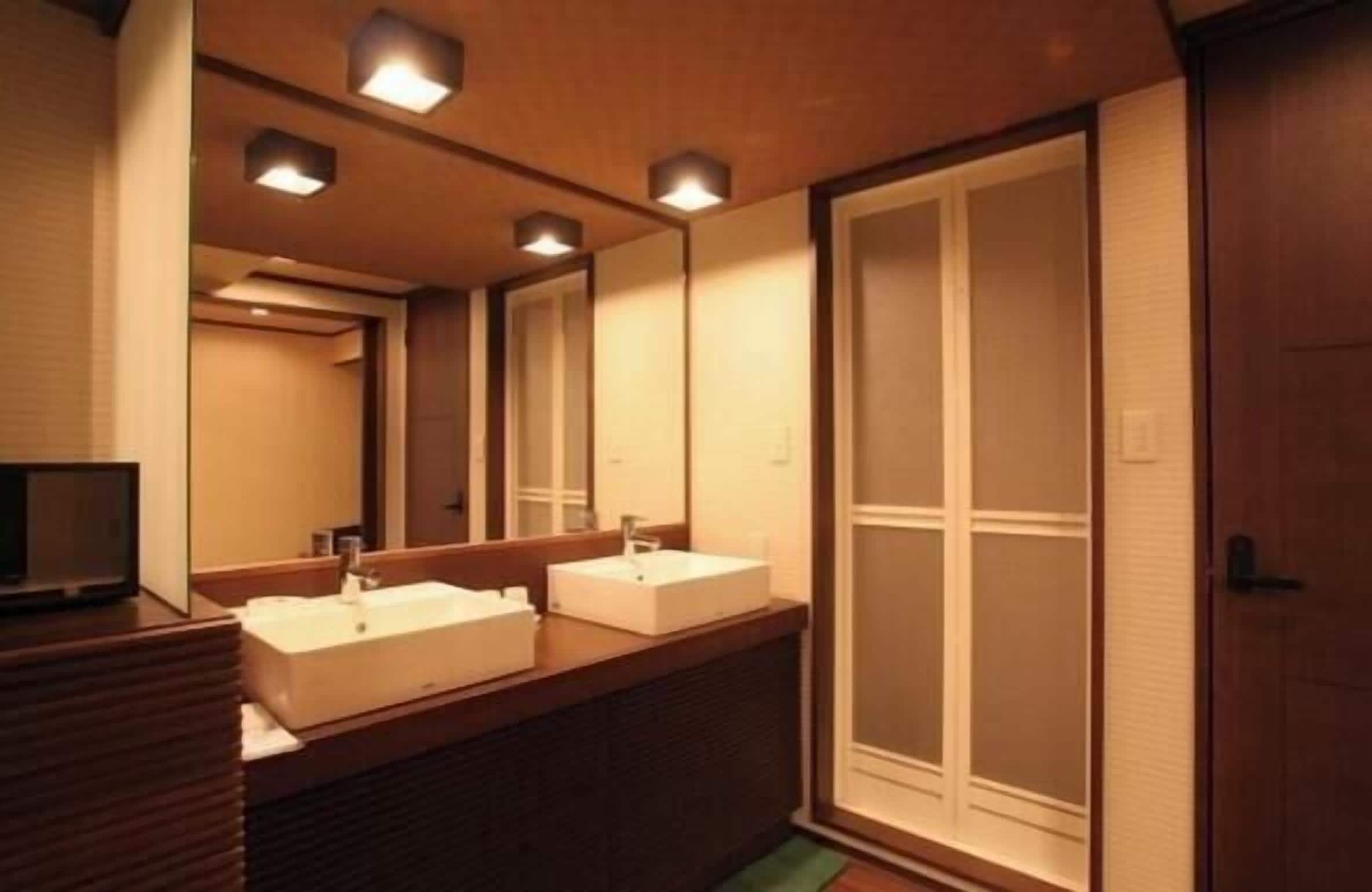 A bathroom with two sinks, a mirror, and a sliding door.