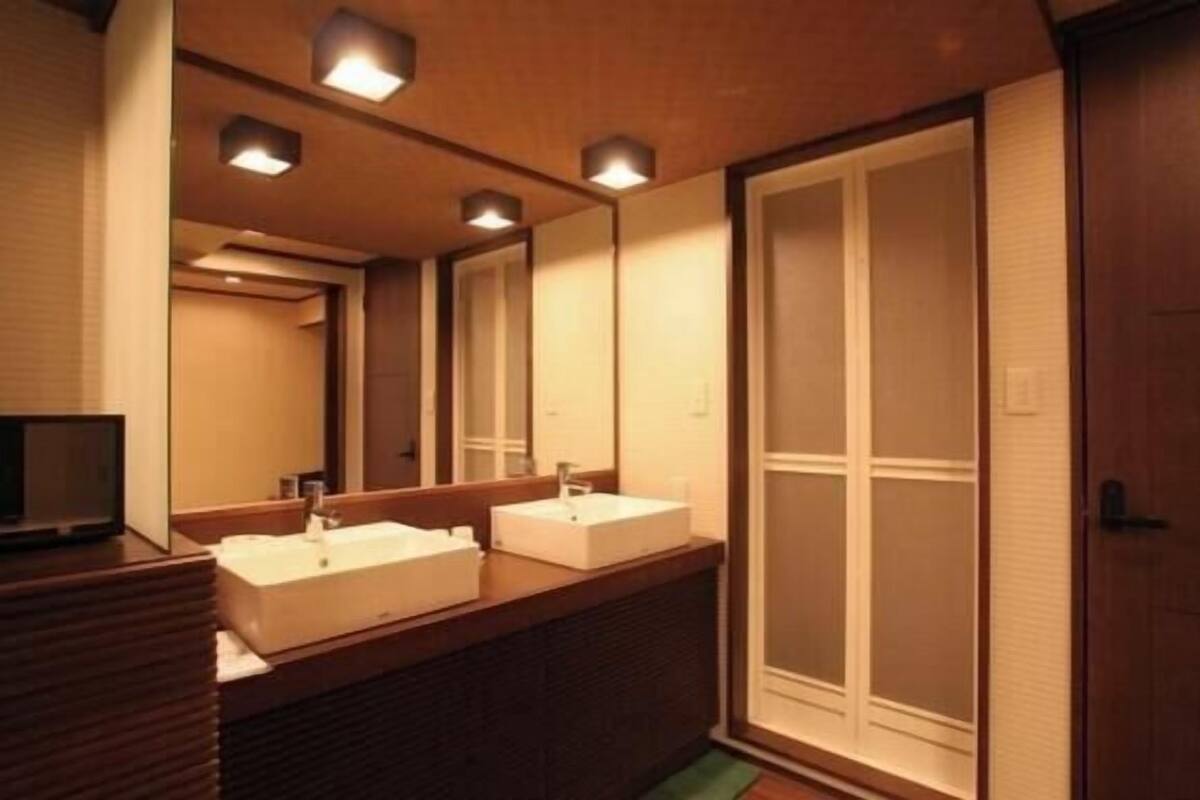A bathroom with two sinks, a mirror, and a sliding door.